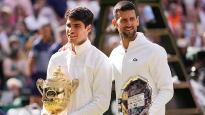 Carlos Alcaraz of Spain holds his trophy as he stands with Novak Djokovic of Serbia after winning the men's singles final at the Wimbledon tennis championships in London, Sunday, July 14, 2024. (AP) Carlos Alcaraz of Spain holds his trophy as he stands with Novak Djokovic of Serbia after winning the men's singles final at the Wimbledon tennis championships in London, Sunday, July 14, 2024. (AP)