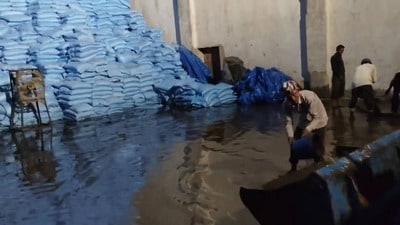 Workers at the inundated godown on Monday. (HT Photo)