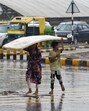 Children try to shield themselves from showers in Gurugram on Monday. (Parveen Kumar/Hindustan Times) Children try to shield themselves from showers in Gurugram on Monday. (Parveen Kumar/Hindustan Times)