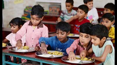 Students at a basic primary school in Gosainganj area enjoying kheer in lunch as schools reopened on Tuesday after the summer vacation. (Deepak Gupta/HT Photo)