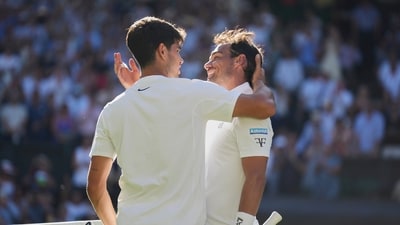 Carlos Alcaraz, left, greets Fabio Fognini at the net after winning their first round men's singles match at the Wimbledon Championships in London (AP)