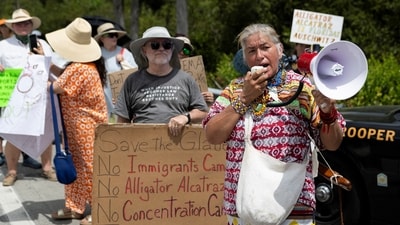 Betty Osceola of the Miccosukee Panther Clan uses a bullhorn as pro-immigrant protesters, environmental groups, Everglades advocates, members of the Miccosukee Native American community and residents gather outside the Dade-Collier Training and Transition Airport as they rally against the state's forthcoming 'Alligator Alcatraz' ICE detention center in Ochopee, Florida (REUTERS)