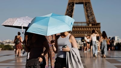 Tourists hold umbrellas to protect themselves from the sun during a heatwave at the Trocadero square, in Paris, on June 30, 2025. (AFP) Tourists hold umbrellas to protect themselves from the sun during a heatwave at the Trocadero square, in Paris, on June 30, 2025. (AFP)