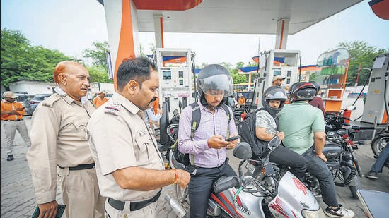 Police officers inspect a bike at a pump in Delhi. (Sanchit Khanna/HT)