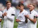 England's Ben Stokes applauds with teammates as they line up during the national anthems before the match