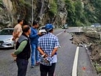 People look at a partially caved in portion of a road, following rainfall at Manali, in Kullu district, Himachal Pradesh.