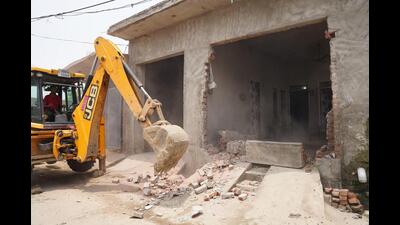 The police in coordination with the district administration demolished three illegal constructions owned by drug smugglers on panchayati land at Dogranwal village on Wednesday. (HT Photo)