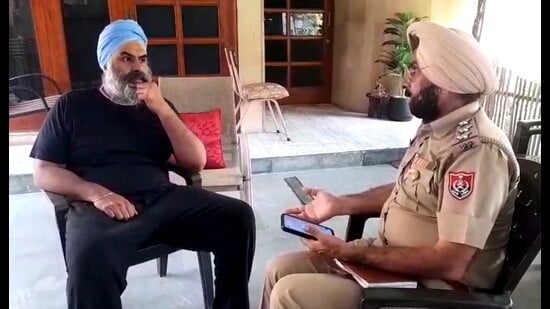 SAD leader Maheshinder Singh Grewal’s son, Hitesh Singh Grewal talking to a police official at their house in Ludhiana on Wednesday. (HT Photo)