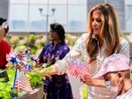First lady Melania Trump places an American flag pinwheel in a courtyard garden First lady Melania Trump places an American flag pinwheel in a courtyard garden