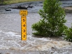 A flood gauge marks the height of water flowing over a farm-to-market road near Kerrville, Texas, on Friday