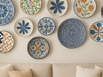 A cosy living room wall styled with eclectic wall plates, mixing patterns and textures to create a warm, collected look.