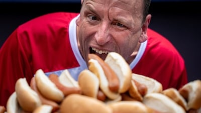 Joey Chestnut, 16-time champion, pretends to eat from a pile of 76 hot dogs, the amount he broke a record with, at the official Weigh-in ceremony, (REUTERS)