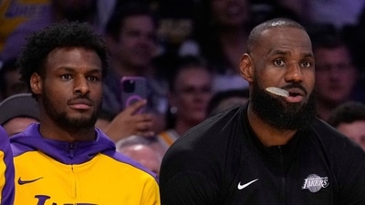 Los Angeles Lakers forward LeBron James, center, sits on the bench with guard Bronny James (AP) Los Angeles Lakers forward LeBron James, center, sits on the bench with guard Bronny James (AP)
