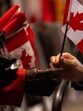 A new Canadian citizen takes a flag during a citizenship ceremony at Canada Place on Canada Day in Vancouver, British Columbia, Canada, on Tuesday. (Bloomberg) A new Canadian citizen takes a flag during a citizenship ceremony at Canada Place on Canada Day in Vancouver, British Columbia, Canada, on Tuesday. (Bloomberg)