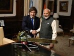 Handout picture released by the Argentinian Presidency showing India's Prime Minister Narendra Modi (R) and Argentina's President Javier Milei posing for a picture behind a chainsaw reading "The Forces of Heaven" during a meeting at Casa Rosada government palace in Buenos Aires on July 5, 2025.