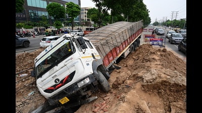 The truck driver said after noticing a heap of mud, he took a slight turn but his vehicle plunged into the sinkhole. (Sanjeev Sharma/HT) The truck driver said after noticing a heap of mud, he took a slight turn but his vehicle plunged into the sinkhole. (Sanjeev Sharma/HT)