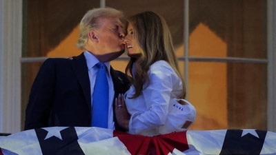 U.S. President Donald Trump kisses first lady Melania Trump as they stand at a balcony to watch the  during Fourth of July celebrations at the White House, in Washington, D.C., U.S., July 4, 2025. REUTERS/Ken Cedeno (REUTERS)