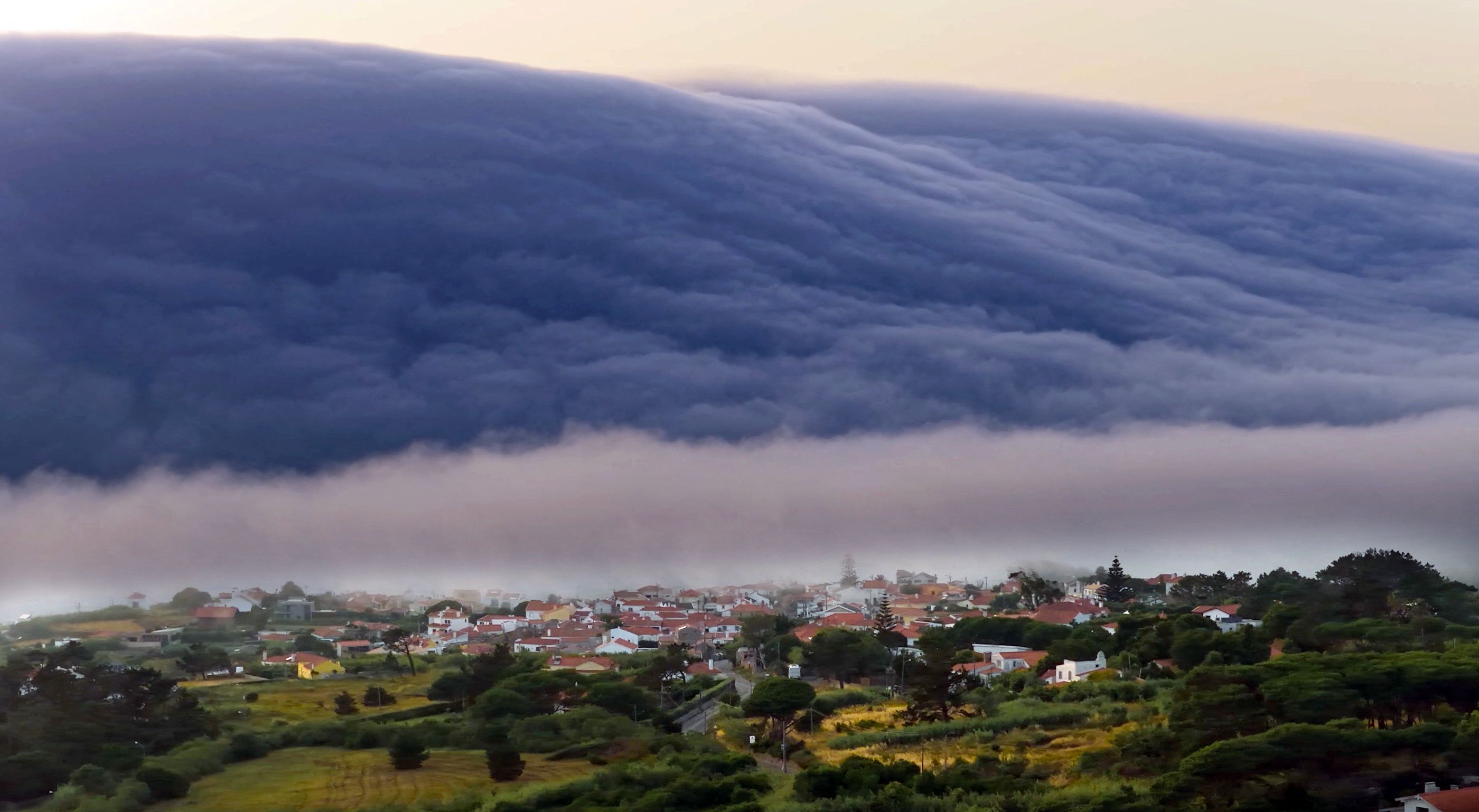A rare "roll cloud", a huge horizontal bank, advances from the horizon towards the beaches of the Atlantic Ocean during a heatwave in southwestern Portugal, in June. (AFP) A rare "roll cloud", a huge horizontal bank, advances from the horizon towards the beaches of the Atlantic Ocean during a heatwave in southwestern Portugal, in June. (AFP)