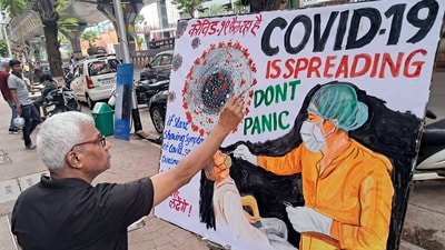 A teacher of the Gurukul School of Art makes an awareness painting of COVID-19, in Mumbai. (ANI)