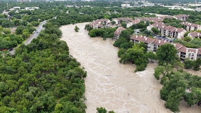People look at the Guadalupe river, following flash flooding, in Kerrville, Texas (REUTERS)