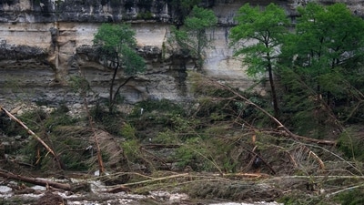 A Texas Department of Public Safety official, bottom left, combs through the banks of the Guadalupe River near Camp Mystic after a flash flood swept through the area Saturday, July 5, 2025, in Hunt, Texas. (AP Photo/Julio Cortez) A Texas Department of Public Safety official, bottom left, combs through the banks of the Guadalupe River near Camp Mystic after a flash flood swept through the area Saturday, July 5, 2025, in Hunt, Texas. (AP Photo/Julio Cortez)