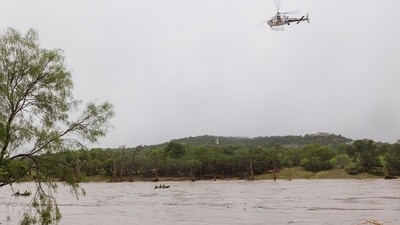 A helicopter flies over the Guadalupe River after a flash flood swept through the area, in Kerrville, Texas. (AP) A helicopter flies over the Guadalupe River after a flash flood swept through the area, in Kerrville, Texas. (AP)