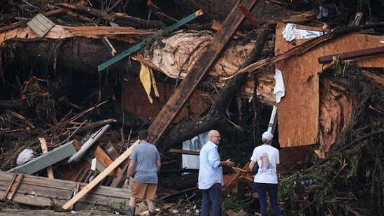People look at debris on the banks of the Guadalupe River after a flash flood swept through the area Saturday, July 5, 2025, in Hunt, Texas.(AP Photo/Julio Cortez)