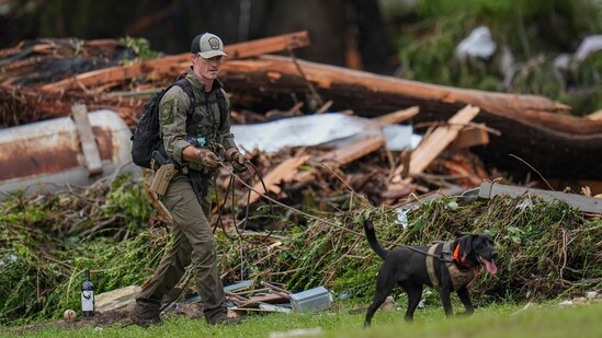 Officials comb through the banks of the Guadalupe River after a flash flood swept through the area Saturday, July 5, 2025, in Hunt, Texas.(AP Photo/Julio Cortez)