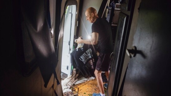 Thomas Rux, a resident of Riverside RV Park, goes through the wreckage of his RV that was swept away by floodwaters in Ingram, Texas, on Friday.(AP)