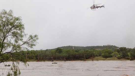 A helicopter flies over the Guadalupe River after a flash flood swept through the area, in Kerrville, Texas.(AP)