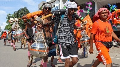 Kanwariyas (Shiva devotees) carry pots filled with water collected from Gangariver during the annual 'Kanwar Yatra'. (ANI)