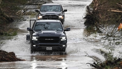 Trucks drive through a flooded and damaged road in Hunt, Texas, on July 6, 2025, following severe flash flooding that occured during the July 4 holiday weekend. (Photo by RONALDO SCHEMIDT / AFP) (AFP) Trucks drive through a flooded and damaged road in Hunt, Texas, on July 6, 2025, following severe flash flooding that occured during the July 4 holiday weekend. (Photo by RONALDO SCHEMIDT / AFP) (AFP)