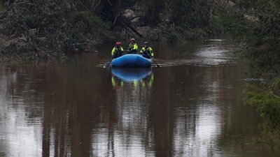 Rescuers paddle an inflatable boat as they search along a waterway following flash flooding, in Kerrville, Texas. (REUTERS)