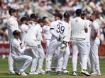 England's Chris Woakes with teammates as they look dejected after an unsuccessful DRS review for the LBW wicket 
