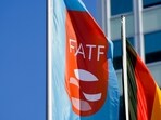A flag with the logo of the Financial Action Task Force, FATF, waves in the wind next to the German national falg during a meeting of the task force at the Congress Center in Berlin, Germany.