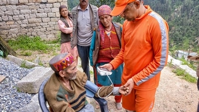 NDRF personnel checking blood pressure of an elderly man during relief and rescue operation after flash floods in Mandi, Himachal Pradesh. (PTI) NDRF personnel checking blood pressure of an elderly man during relief and rescue operation after flash floods in Mandi, Himachal Pradesh. (PTI)