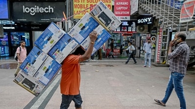 A worker carries a bundle of printers in front of computer and accessories stores in the electronics market in New Delhi. (AFP) A worker carries a bundle of printers in front of computer and accessories stores in the electronics market in New Delhi. (AFP)