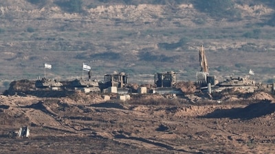 Israeli soldiers and military vehicles operate in Gaza, as seen from the Israeli side of the Israel-Gaza border (REUTERS)