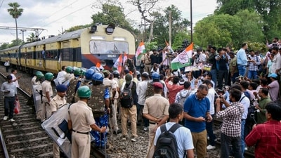Security personnel stand guard as agitators stop a train during a protest amid 'Bihar bandh' called by the INDIA bloc against Special Intensive Revision in the state, at Sachiwalay Halt Railway station in Patna. (PTI)