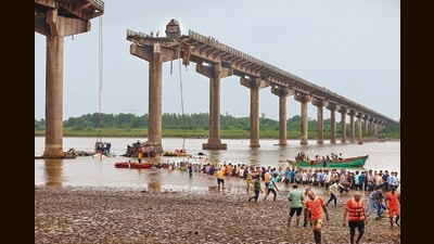 Rescuers and locals look for survivors after the collapse of a portion of a bridge in Gujarat (AP) Rescuers and locals look for survivors after the collapse of a portion of a bridge in Gujarat (AP)
