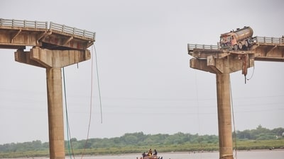 Rescuers and locals look for survivors after several vehicles fell into a river following the collapse of a portion of a bridge in Vadodara district of Gujarat on Wednesday. (AP) Rescuers and locals look for survivors after several vehicles fell into a river following the collapse of a portion of a bridge in Vadodara district of Gujarat on Wednesday. (AP)