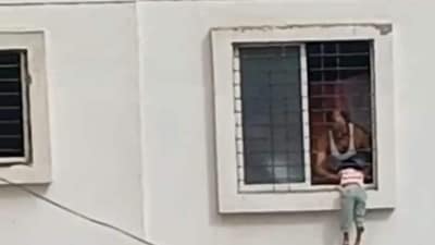 Leaning out of the bedroom window, the girl reportedly slipped and got stuck between the metal grill and the ledge, dangling dangerously several feet above the ground. (VIDEO GRAB) Leaning out of the bedroom window, the girl reportedly slipped and got stuck between the metal grill and the ledge, dangling dangerously several feet above the ground. (VIDEO GRAB)