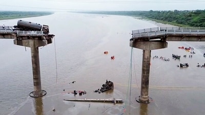 A truck hangs loosely as the Gambhira bridge on the Mahisagar river, connecting Vadodara and Anand, collapses. (ANI Video Grab) A truck hangs loosely as the Gambhira bridge on the Mahisagar river, connecting Vadodara and Anand, collapses. (ANI Video Grab)