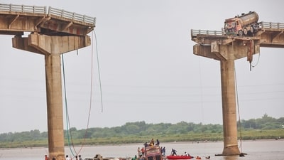 Rescuers and locals look for survivors after several vehicles fell into a river following the collapse of a portion of a bridge in Mujpur near Vadodara in Gujarat. (AP) Rescuers and locals look for survivors after several vehicles fell into a river following the collapse of a portion of a bridge in Mujpur near Vadodara in Gujarat. (AP)