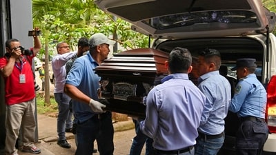 Personnel from the Centre for Legal Medicine and Forensic Sciences carry the coffin with the remains of Francisco Martinez, mayor of the San Isidro municipality, in Tegucigalpa on July 10 (AFP)