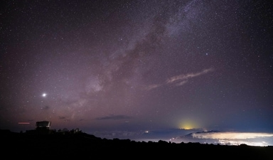 FILE - The Milky Way is seen over the Haleakala Observatory and the lights of Kahului, at right, Saturday, Nov. 23, 2024 at the summit of Haleakala National Park near Kula, Hawaii