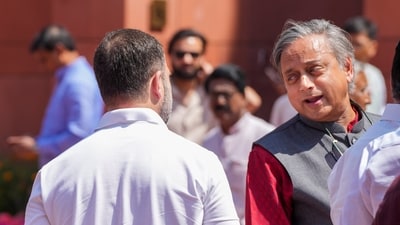 Congress MP Shashi Tharoor saying something to Rahul Gandhi (back to camera) at the Parliament in New Delhi. (PTI File)