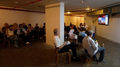 People watch news updates inside a shelter after air raid sirens sounded warning of a fresh barrage of Iranian rockets in the Israeli city of Haifa on June 19, 2025. (AFP) People watch news updates inside a shelter after air raid sirens sounded warning of a fresh barrage of Iranian rockets in the Israeli city of Haifa on June 19, 2025. (AFP)