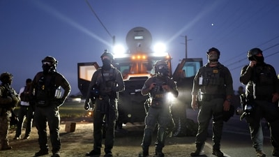 Federal agents block people protesting an ICE immigration raid at a nearby licensed cannabis farm on July 10, 2025 near Camarillo, California. (AFP/Mario Tama) Federal agents block people protesting an ICE immigration raid at a nearby licensed cannabis farm on July 10, 2025 near Camarillo, California. (AFP/Mario Tama)