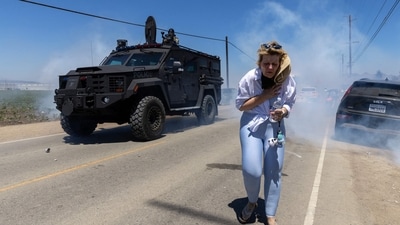 A protestor flees as Customs and Border Protection officers fire chemical agents into the crowd during a raid by Federal Immigration Agents at Glass House Farms in Camarillo, California. (Blake Fagan/AFP) A protestor flees as Customs and Border Protection officers fire chemical agents into the crowd during a raid by Federal Immigration Agents at Glass House Farms in Camarillo, California. (Blake Fagan/AFP)